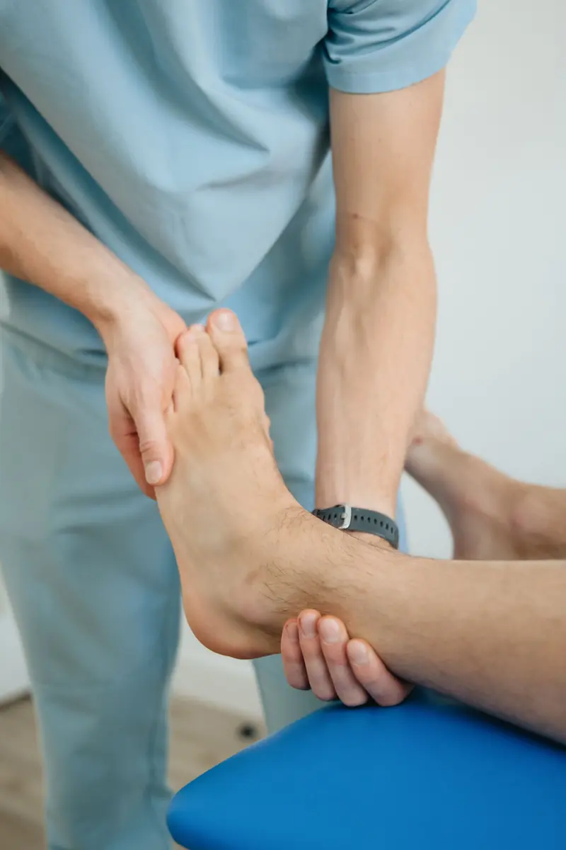Les mains d'un praticien posées sur le pied d'un patient