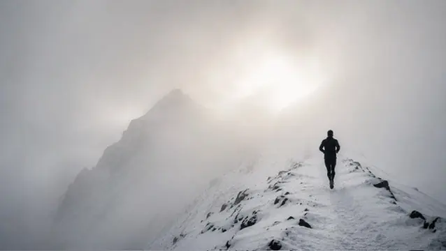 Un coureur sur une crête enneigée