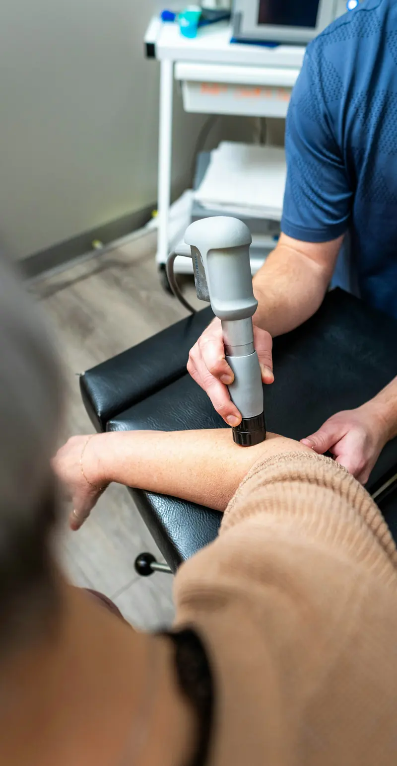 Un praticien utilise un appareil sur l'avant-bras d'un patient