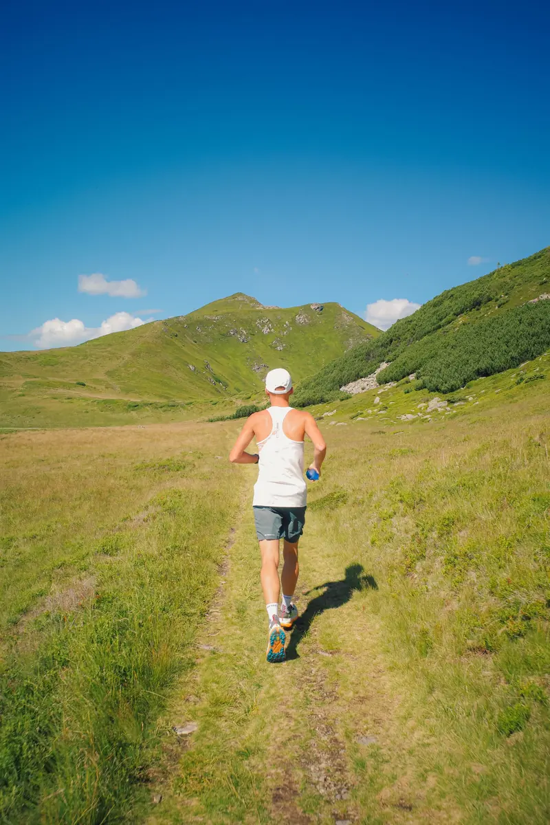 Un coureur sur un sentier de montagne ensoleillé